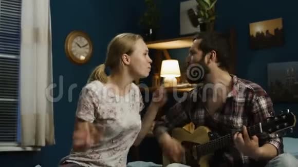 在床上弹吉他唱歌的情侣视频的预览图