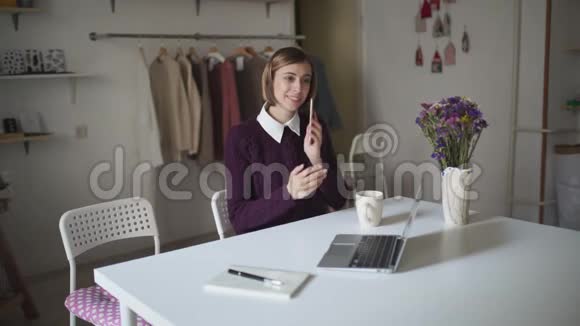 女商人在家工作打手机的年轻女子视频的预览图