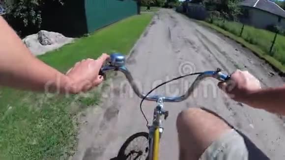 人正骑着自行车在村里的农村公路上从车轮的胸部看视频的预览图