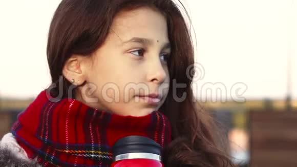 一个体贴的女孩从热杯子里喝一杯热饮料视频的预览图