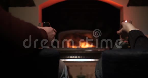 在壁炉背景上戴眼镜的男性手朋友们用坐在火边的眼镜欢呼双手视频的预览图