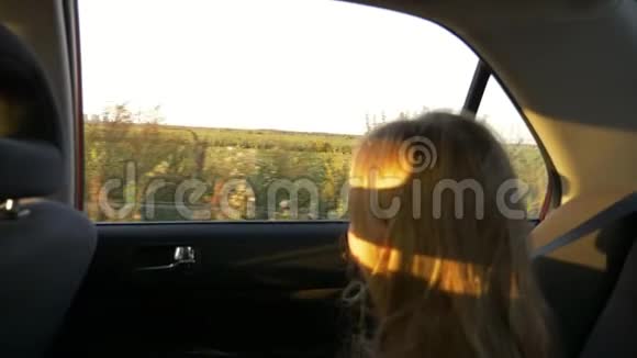 夏夜乘汽车旅行的小女孩窗外的乡村景象注意背景注意力不集中的女孩手持武器视频的预览图