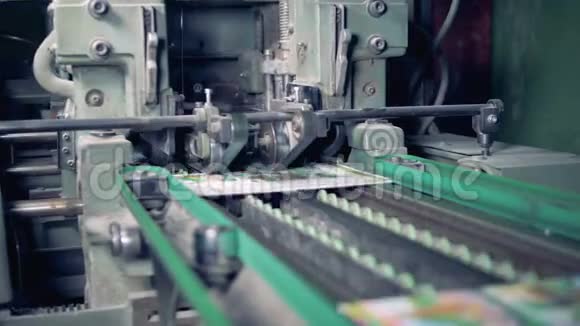 一台工业机器正在切断印刷杂志的边缘视频的预览图