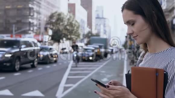 在美国纽约大街上工作的女商人女性在手机上打字视频的预览图