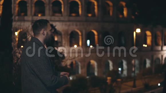 慢动作年轻的幸福夫妇在意大利罗马的斗兽场附近见面拥抱和旋转亲吻视频的预览图