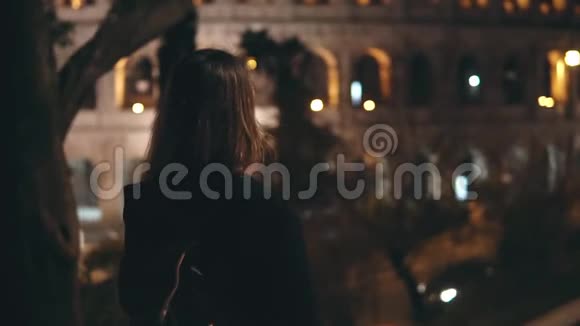 年轻快乐的女人跑在意大利罗马的斗兽场附近回头看微笑着在晚上笑慢动作视频的预览图