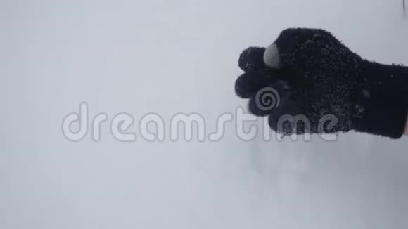 一个穿着冬季手套的人在雪地里表现出不同的姿态特写视频的预览图