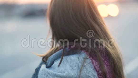 美丽的棕色头发年轻的模特女孩在日落时带着格子呢看上去很沮丧视频的预览图