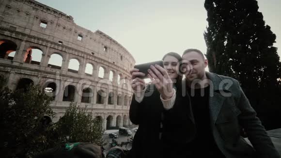 快乐的旅行情侣一起在意大利罗马斗兽场附近的智能手机上自拍以获得回忆视频的预览图