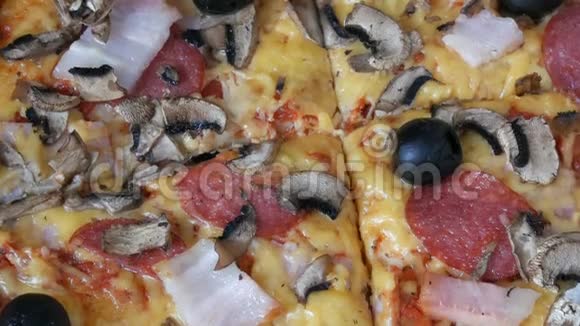 一个意大利大比萨饼放在一个纸板箱里里面有黑色橄榄培根香肠和奶酪视频的预览图