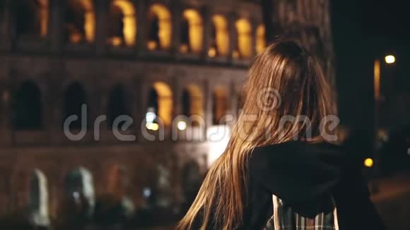 年轻的女游客站在意大利罗马竞技场附近举起双手看着建筑慢点视频的预览图