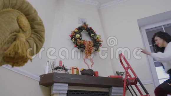 少女在壁炉上装饰圣诞花环视频的预览图