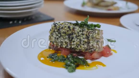 在一个蔬菜垫上两个白盘上面有面包鱼黑和白芝麻用酱油和一个视频的预览图