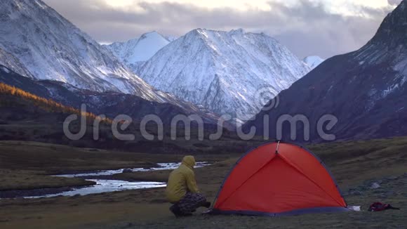 这个人正在山景背景上搭帐篷4k视频的预览图