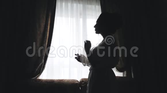 一个女孩在明亮的窗户前美丽的轮廓视频的预览图