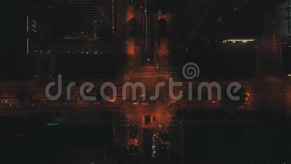 空中无人驾驶飞机俯视大型十字路口的夜间城市道路交通汽车和公共汽车在大街上行驶视频的预览图