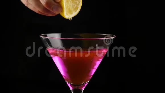 特写的女人把黄色柠檬挤在酒精鸡尾酒里慢动作视频的预览图