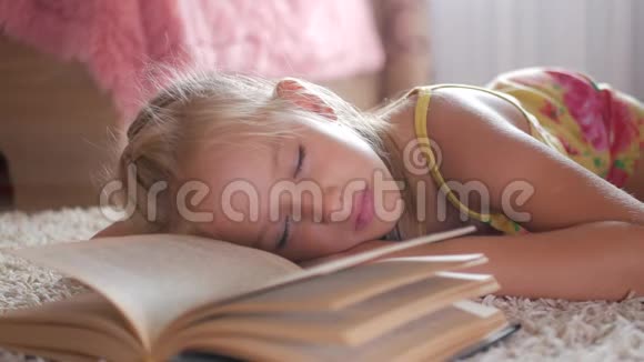 画像悲伤的女学生不想读书读书一个可爱的金发女孩睡在书上她累了视频的预览图