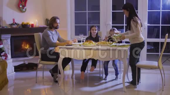 快乐家庭在圣诞餐桌上吃喜庆的晚餐视频的预览图