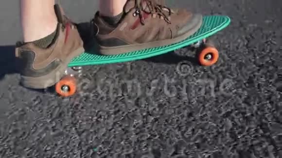 穿运动鞋的腿在绿色滑板上视频的预览图