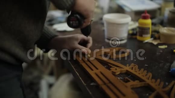 木匠车间用螺丝刀把衣架固定在奖牌上视频的预览图
