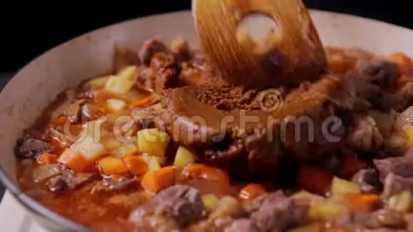 将咖喱肉放入煎锅中然后与牛肉土豆和胡萝卜混合视频的预览图
