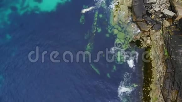 飞越苏格兰海岸线清澈的蓝色海水和岩石视频的预览图