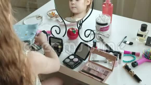 红发小女孩选择眼影照镜子化妆脸时尚风格化妆品特写视频的预览图