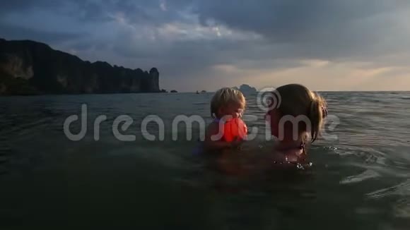 日落时分与母亲在海上沐浴的女孩视频的预览图