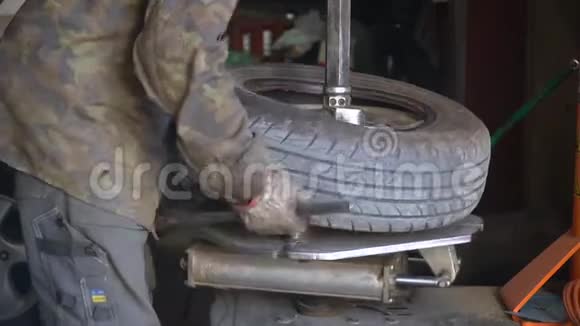 由机械师修理汽车爆胎在换胎器的帮助下从合金车轮上取出轮胎的过程视频的预览图