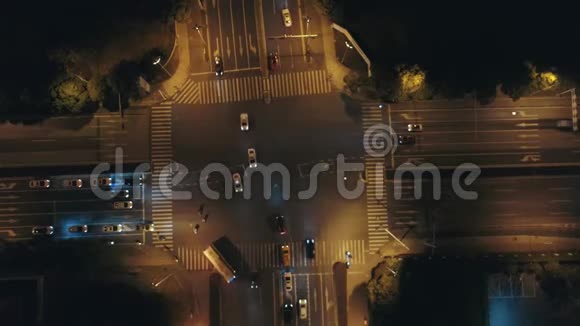 空中无人驾驶飞机俯瞰城市道路交通在夜间的大十字路口汽车和公共汽车在大街上行驶视频的预览图