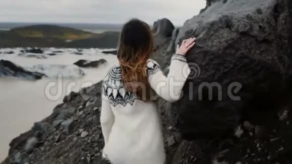 在冰岛的Vatnajokull冰泻湖附近年轻的探险家妇女在山岩中行走视频的预览图