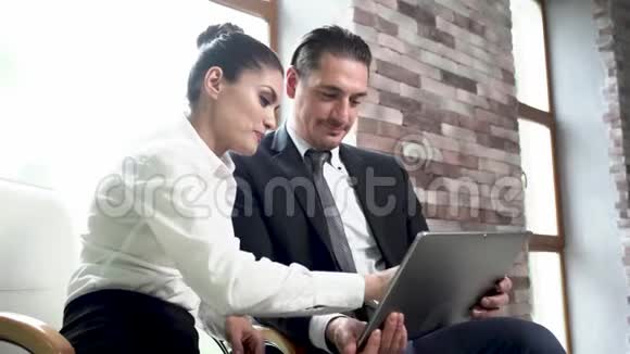 商人和女商人坐下来讨论视频的预览图