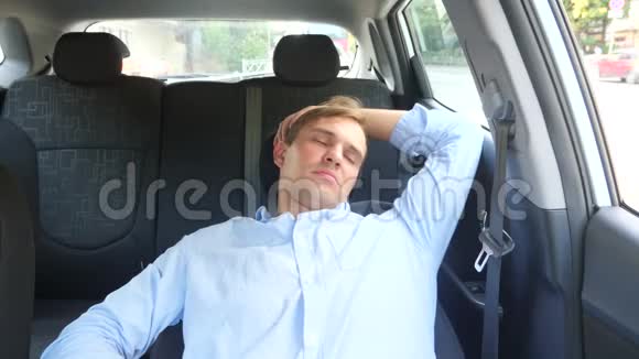 那个人的司机在繁忙路边的驾驶座上睡着了在车里等着视频的预览图