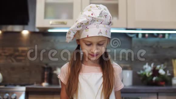 女孩的肖像向镜头展示她如何用釉装饰饼干视频的预览图