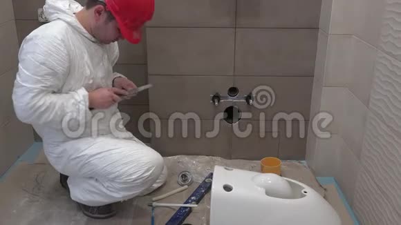 熟练的水管工在新的现代浴室工作手上安装马桶视频的预览图