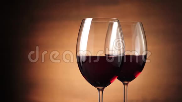 豪华红酒美味的葡萄酒由两个酒杯中的美味红葡萄在棕色背景下制成视频的预览图