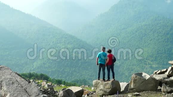 一对夫妇站在雾蒙蒙的大石头上视频的预览图