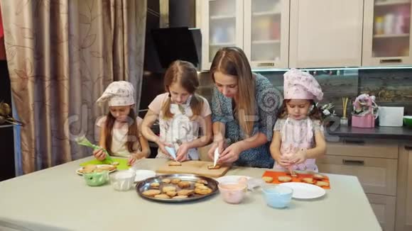 母亲帮助女儿用釉装饰饼干视频的预览图