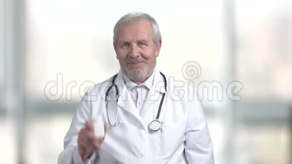 老年医生拿着瓶子和药丸视频的预览图