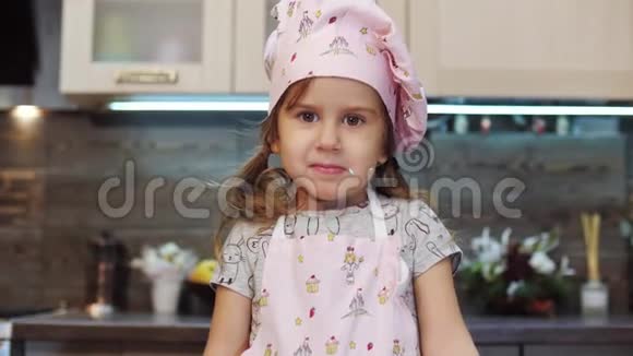 女孩的肖像向镜头展示她如何用釉装饰饼干视频的预览图