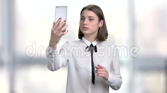 年轻女子拿着智能手机说话视频的预览图