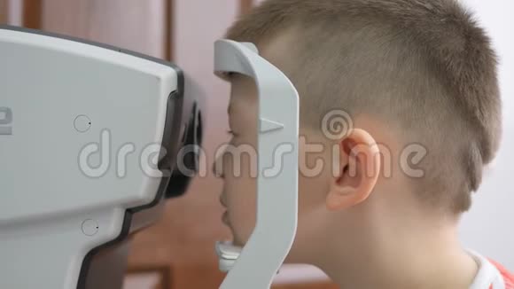 在眼科诊所的孩子小男孩在眼睛检查中看着眼压计视频的预览图