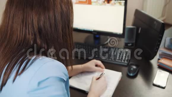 穿着蓝色夹克衫的女商人在办公室的办公桌上写日记视频的预览图