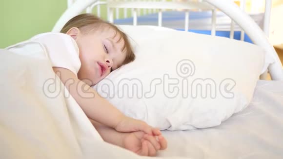可爱的宝宝在家里房间的床上睡在白色的床上睡孩子的概念孩子想睡觉视频的预览图