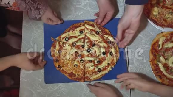 无法辨认的成人和儿童吃比萨饼片的俯视图视频的预览图