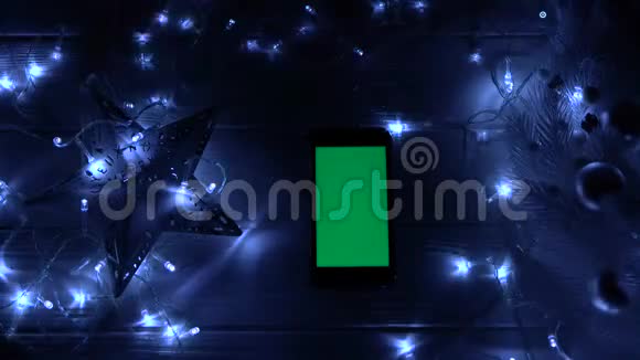 圣诞花环在智能手机桌上的黑暗房间里燃烧顶部视图视频的预览图