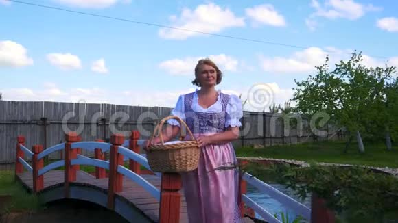 一个穿着民族服装的女人站在一座美丽的桥旁穿过一个池塘视频的预览图