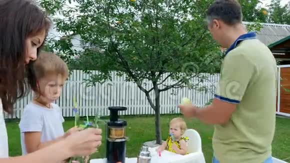 夏天在花园里一家人摆好桌子母子做一束花父亲用它喂女儿视频的预览图