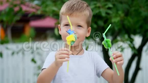 夏天在花园里动作缓慢一个四岁的男孩已经把稻草装饰成了果汁这个男孩非常喜欢它们视频的预览图